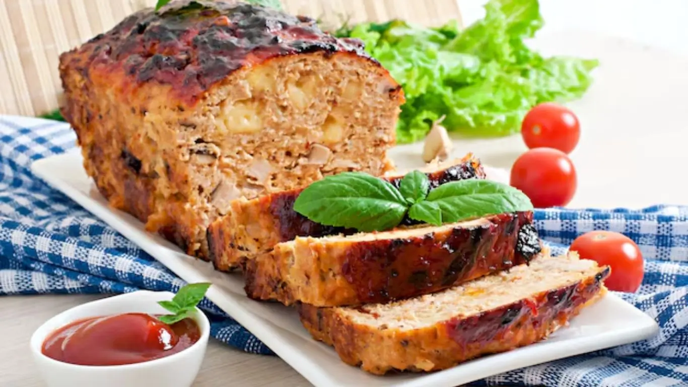 Smoked meatloaf sliced on a wooden board, showing its juicy interior and smoky crust, served with mashed potatoes